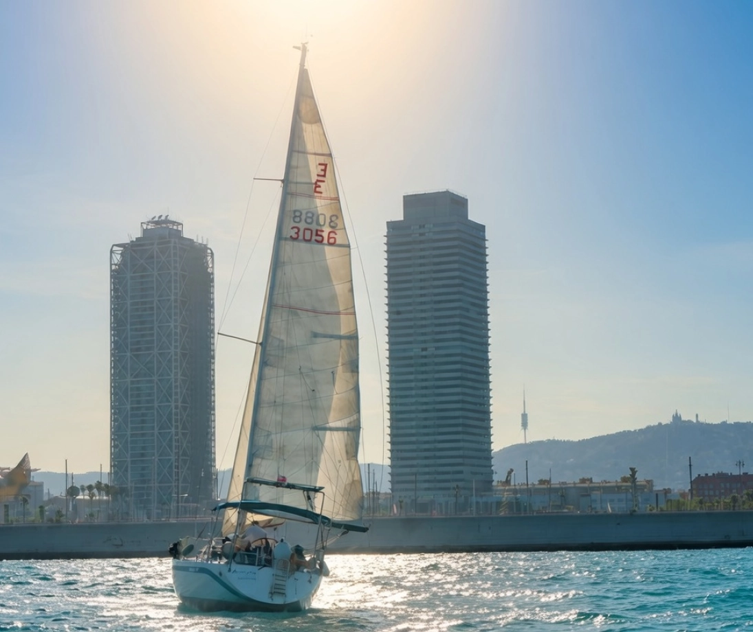 Gruppe von Personen, die einen Ausflug auf einer luxuriösen Segelyacht genießt und bei Sonnenuntergang in der Nähe der Stadt segelt