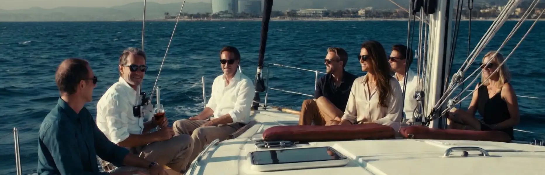 Grupo de amigos disfrutando de un charter en velero de lujo frente a la costa de Barcelona