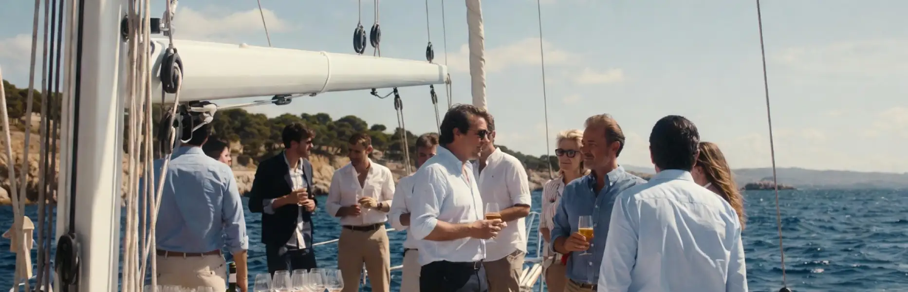 Gruppe von Personen, die einen luxuriösen Charter auf einer privaten Segelyacht auf dem Meer an einem sonnigen Tag genießt