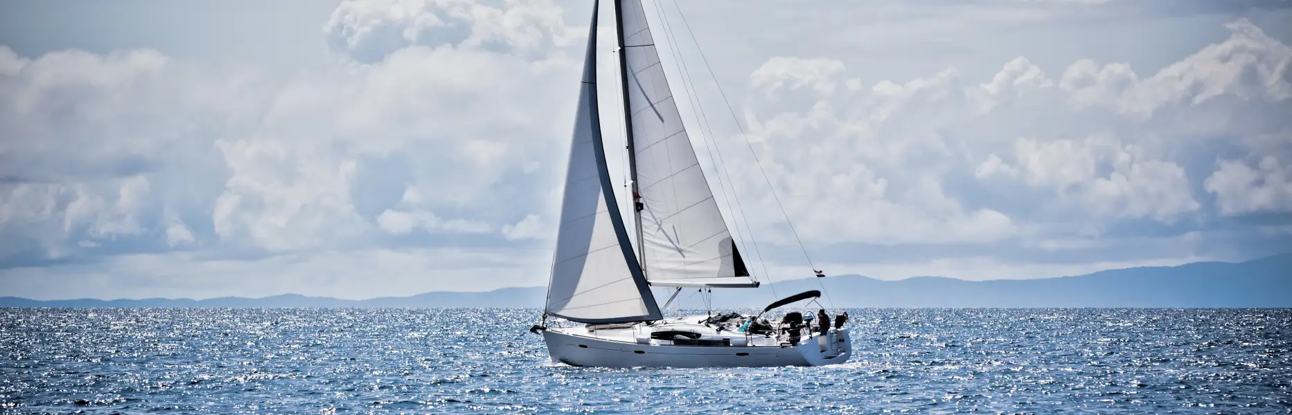 Charter sailing boat cruising with a small group off the Mediterranean Sea on a clear day
