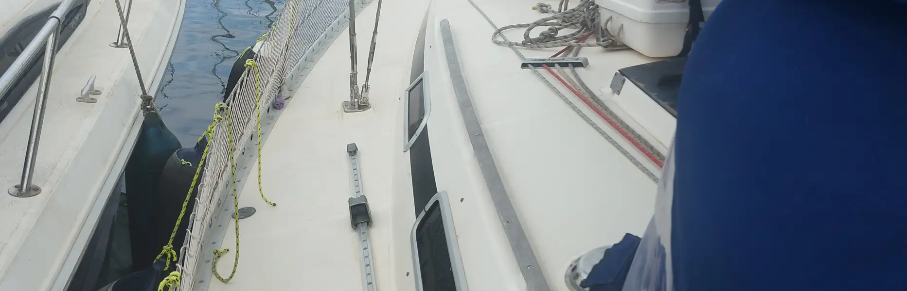 Vista de la cubierta de un velero amarrado en el puerto deportivo rodeado de otros barcos