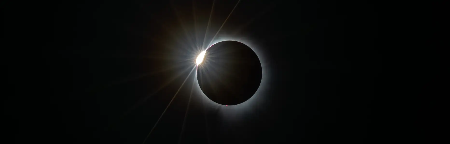 Diamantringphase der totalen Sonnenfinsternis mit leuchtender Korona vor schwarzem Hintergrund