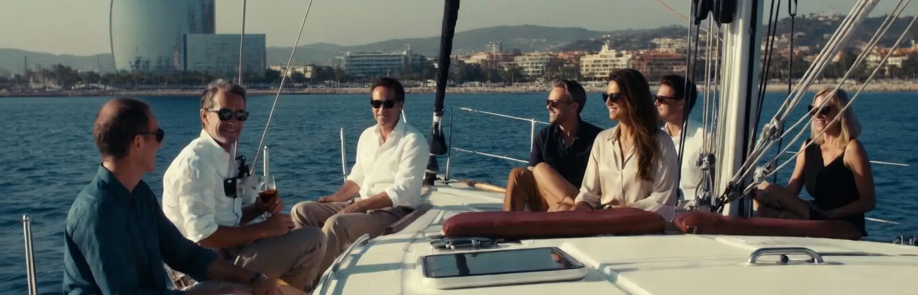 Groupe d'amis profitant d’un charter de luxe en voilier au large de la côte de Barcelone par une journée ensoleillée