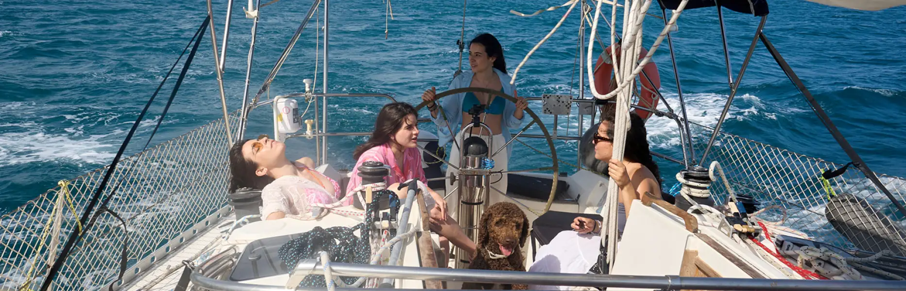 Groupe d’amies se détendant sur le pont d’un voilier lors d’une croisière privée au large de Barcelone